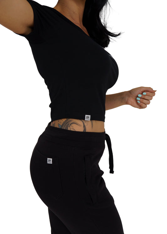 Frau trägt schwarzen BlockRebell Jogger und Cropped Shirt – sportliches Streetwear-Outfit für Damen