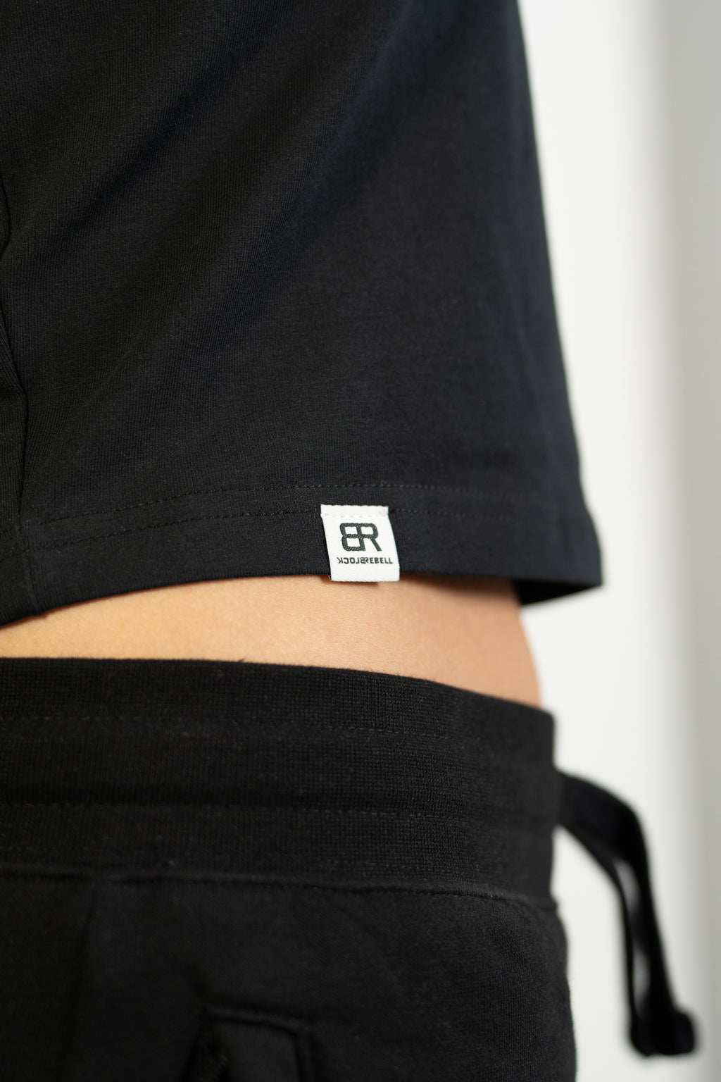 Frau trägt BlockRebell Cropped Shirt und Jogger – sportlich-lässiger Streetwear-Look für Damen