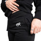 Frau trägt schwarzen BlockRebell Jogger und Cropped Shirt – sportliches Streetwear-Outfit für Damen