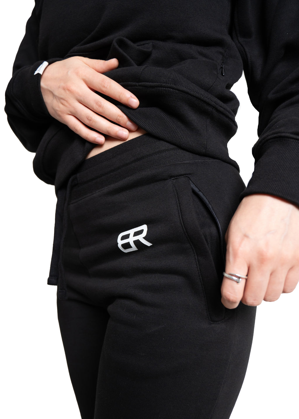 Frau trägt schwarzen BlockRebell Jogger und Cropped Shirt – sportliches Streetwear-Outfit für Damen