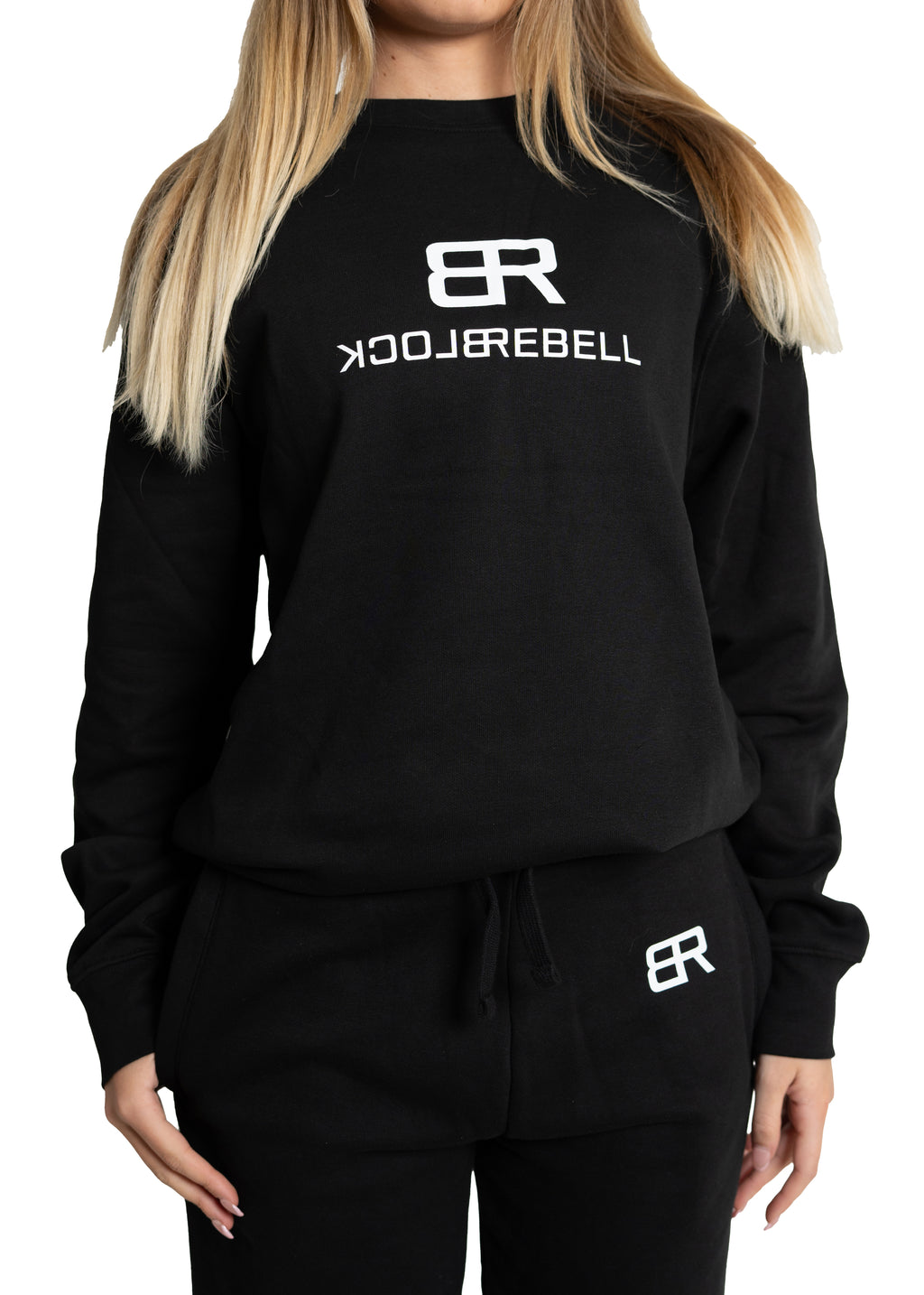 Frau trägt schwarzen Rebell Sweater und Jogger von BlockRebell – sportlich-lässiger Look auf weißem Hintergrund