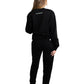 Frau trägt schwarzen Rebell Sweater und Jogger von BlockRebell – sportlich-lässiger Look auf weißem Hintergrund